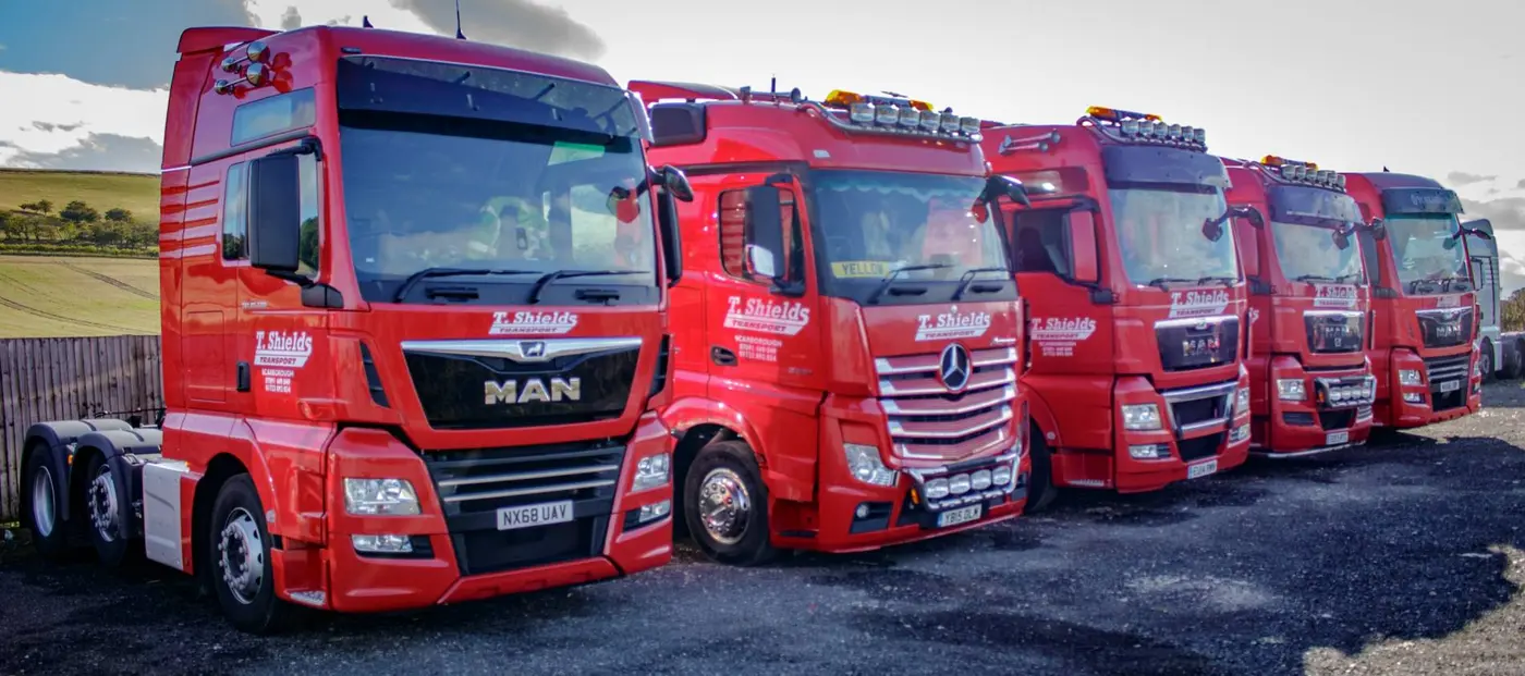 Row of red T Shields Transport tractor units ready for UK deliveries