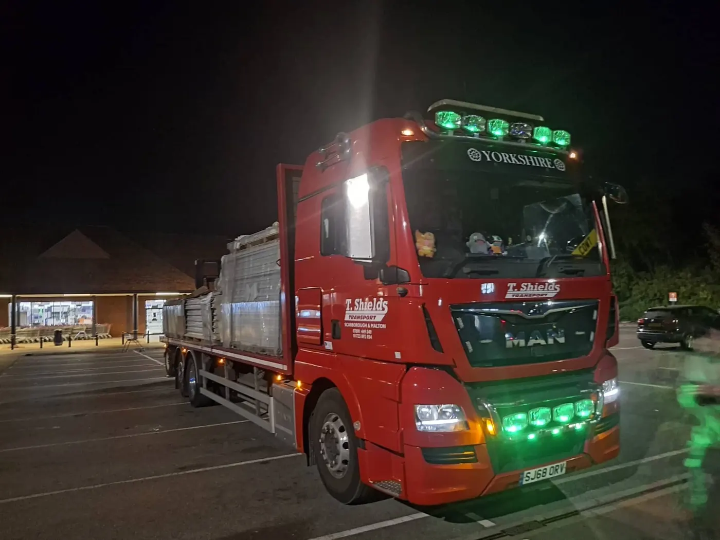 Red MAN flatbed lorry on an overnight delivery T Shields Transport North Yorkshire